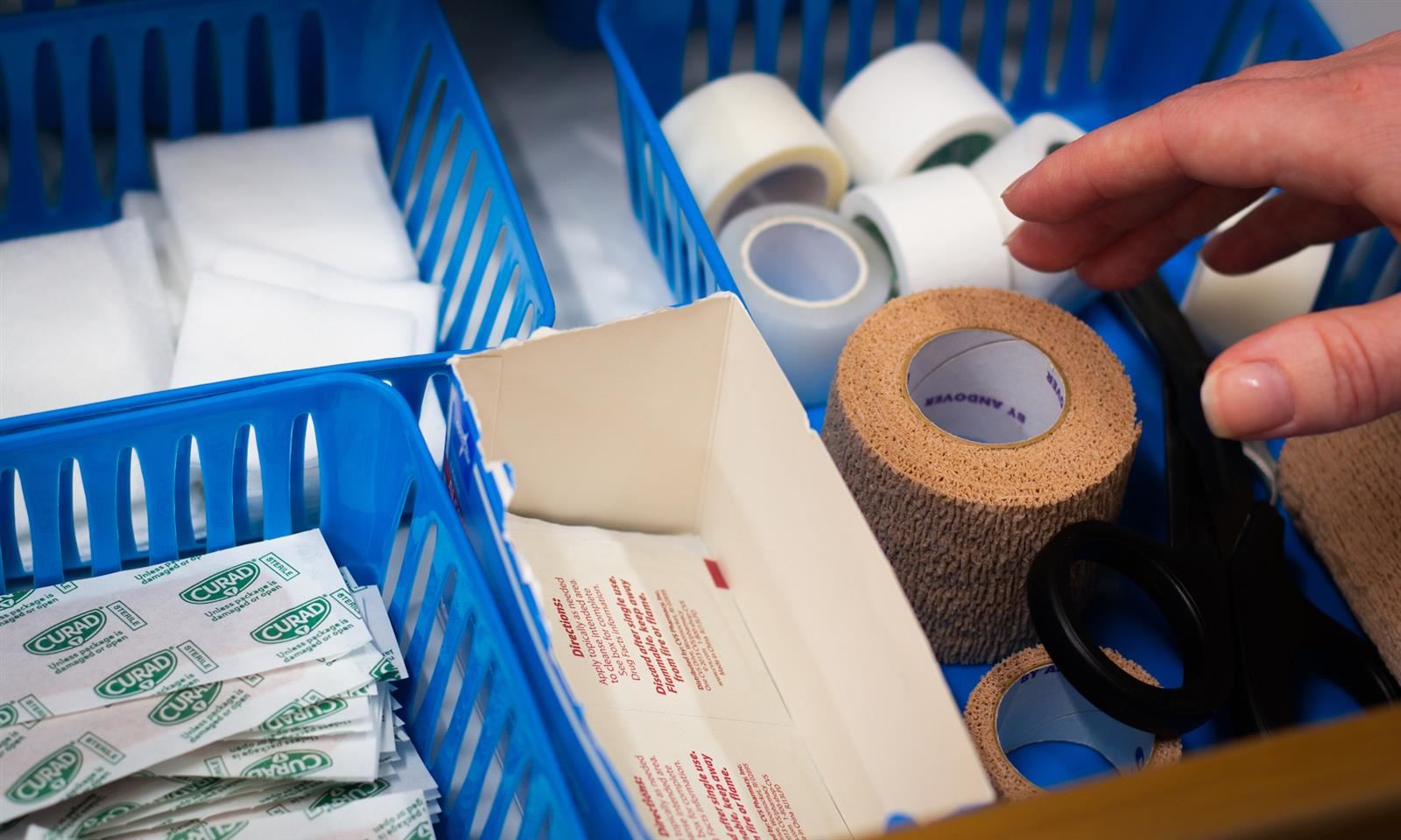 Medical supplies in a drawer with a hand reaching in